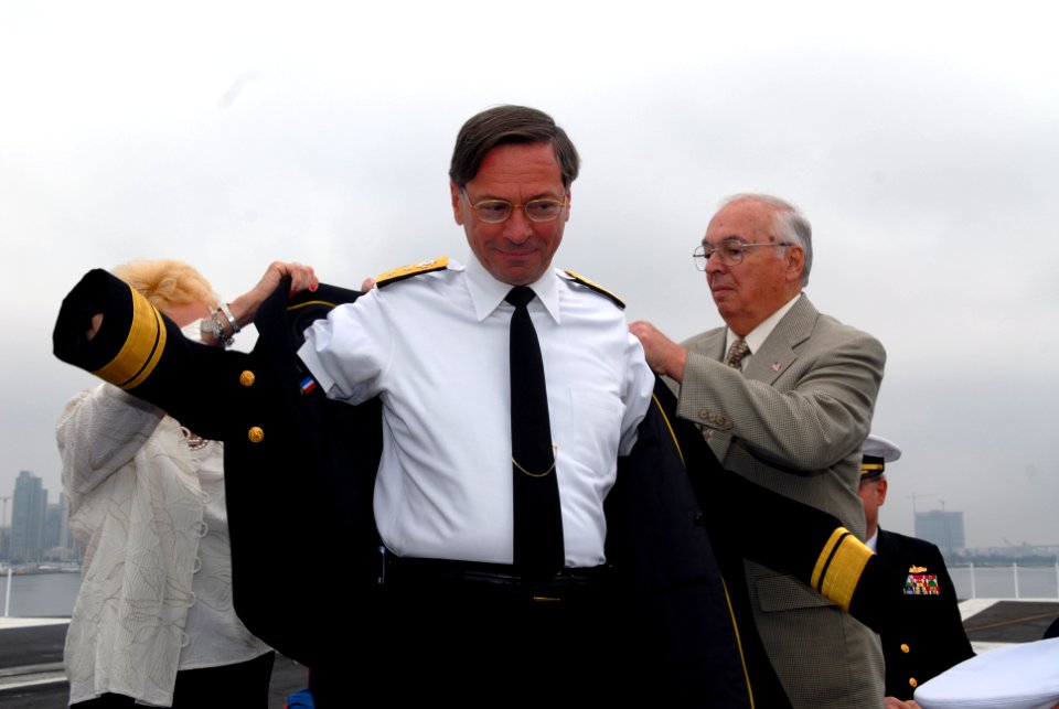 US Navy 071116-N-2959L-157 Rear Adm. Charles Martoglio puts on his new service dress blue jacket with help from his parents during the Carrier Strike Group (CCSG) 7 change of command