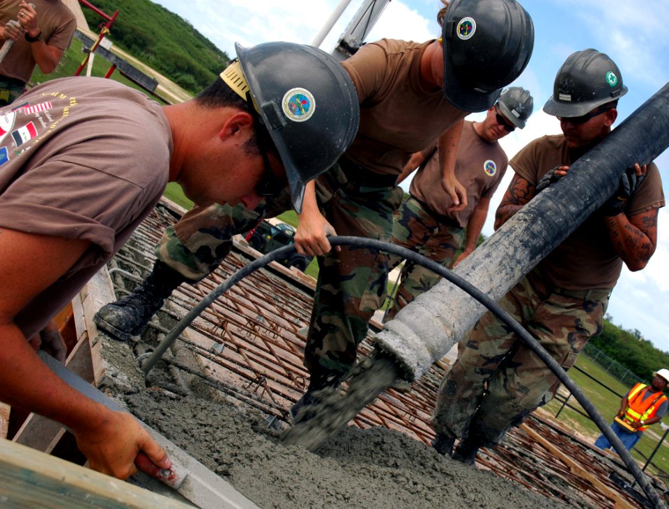 US Navy 071121-N-7367K-008 Seabees attached to Naval Mobile Construction Battalion (NMCB) 1, Guam Det., work together at an overhead concrete pour at the Orote Point concrete masonry unit-block mechanics' shop on board Naval Ba