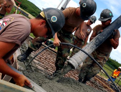 US Navy 071121-N-7367K-008 Seabees attached to Naval Mobile Construction Battalion (NMCB) 1, Guam Det., work together at an overhead concrete pour at the Orote Point concrete masonry unit-block mechanics' shop on board Naval Ba