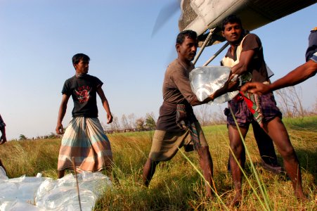 US Navy 071127-N-5642P-154 Local residents assist in unloading bags of fresh water from a CH-53E Sea Stallion helicopter attached to Marine Medium Helicopter Squadron (HMM) 261 photo