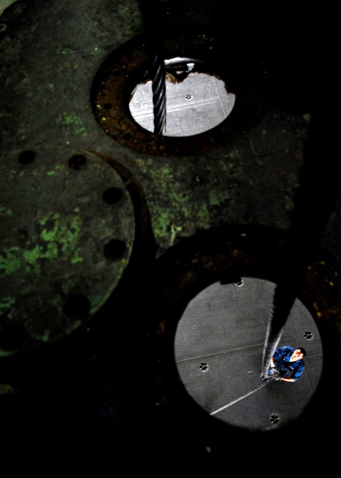 US Navy 071117-N-7981E-303 Aviation Boatswain's Mate (Equipment) Airman Austin Lewis, assigned to Air Department's V-2 Division, guides fresh arresting cable from the hangar bay aboard the Nimitz-class nuclear-powered aircraft