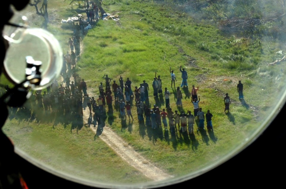 US Navy 071126-N-1831S-283 Local citizens wave goodbye to the crew a CH-46E Sea Knight helicopter assigned to Marine Medium Helicopter Squadron (HMM) 261 after they delivered water to help aid the victims of Tropical Cyclone Si