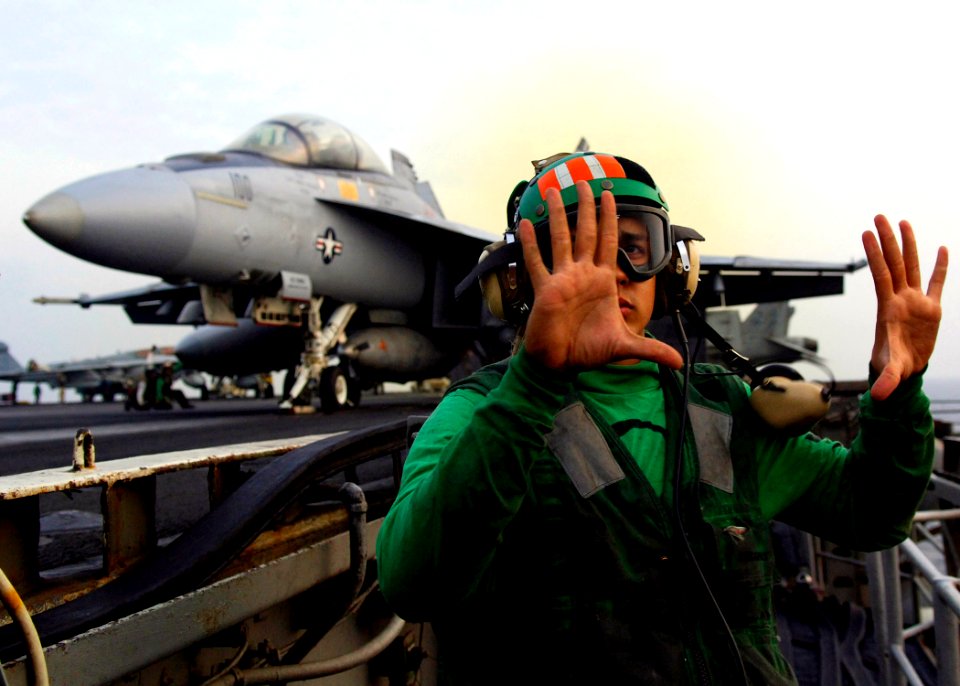 US Navy 071123-N-6524M-004 The deck edge operator signals his hands are free of the launch controls prior to launching an F-A-18F Super Hornet