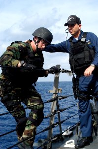 US Navy 071126-N-9123L-008 Chief Gunner's Mate Paul Beinlich assists Gunner's Mate 2nd Class Robert Wheeler during a