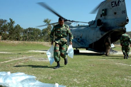 US Navy 071126-N-1831S-104 A member of the Bangladesh Army helps unload bags of purified water from a CH-46 Sea Knight assigned to the amphibious assault ship USS Kearsarge (LHD 3)