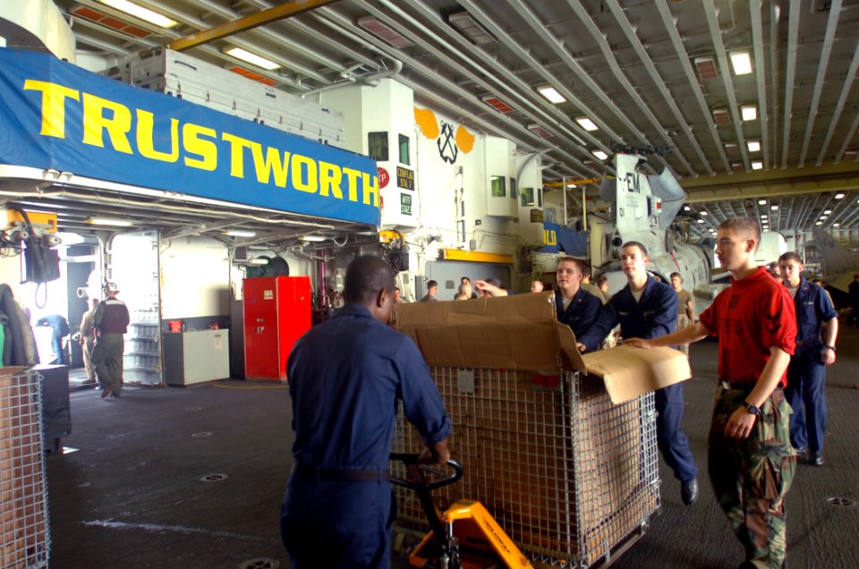 US Navy 071127-N-1831S-215 Sailors aboard the amphibious assault ship USS Kearsarge (LHD 3) move boxes of water to the hangar bay elevator so they can load them onto helicopters