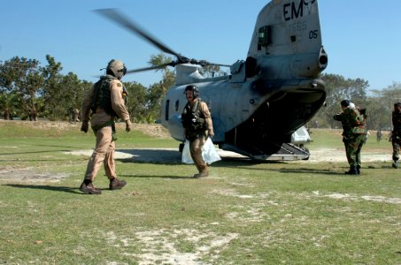 US Navy 071126-N-1831S-102 Marine pilots from a CH-46 Sea Knight helicopter, assigned to amphibious assault ship USS Kearsarge (LHD 3), help distribute purified water in Bangladesh photo