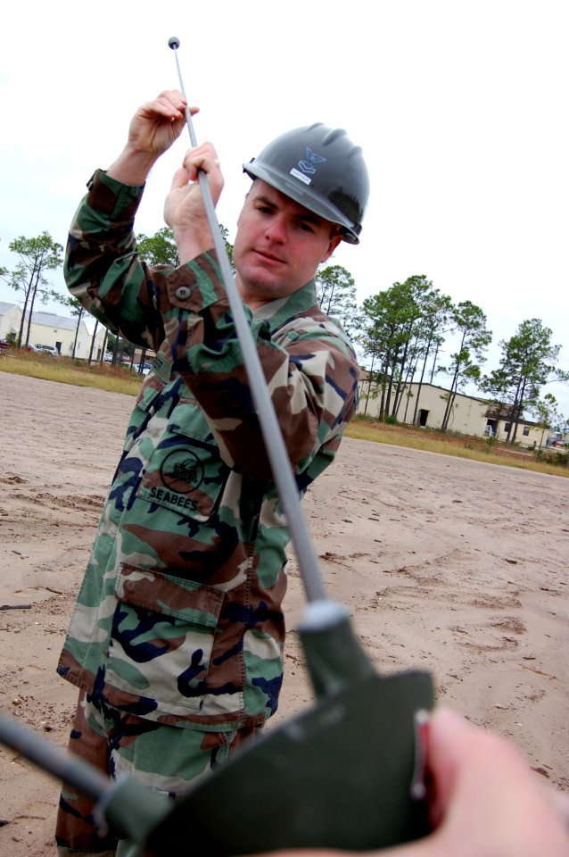 US Navy 071127-N-1057H-708 Utilitiesman 2nd Class Jeffery Napier attaches antennae probes to the feed horn of an OE-254-GRC antennae during the Naval Mobile Construction Battalion (NMCB) 11 communications exercise (COMMEX)