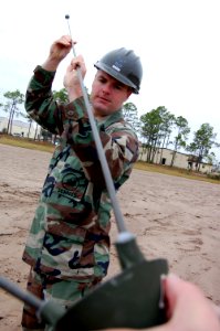 US Navy 071127-N-1057H-708 Utilitiesman 2nd Class Jeffery Napier attaches antennae probes to the feed horn of an OE-254-GRC antennae during the Naval Mobile Construction Battalion (NMCB) 11 communications exercise (COMMEX)