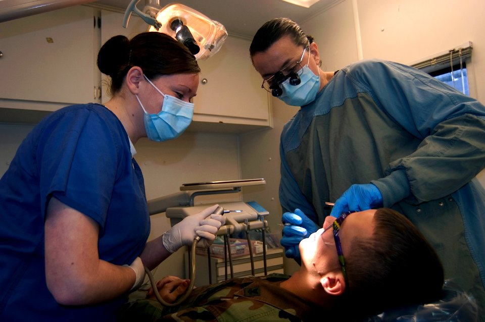 US Navy 071128-N-9520G-002 Lt. Cmdr. Martha Michaelson and Hospitalman Tiffany Ciampo examine Master-at-Arms 2nd Class Jeff Grigsby in Fleet Dental's Mobile Dental Unit (MODENT)