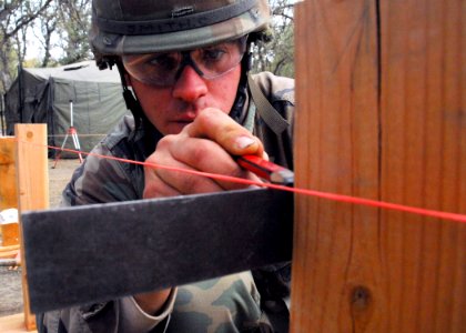 US Navy 071130-N-0775Y-005 Builder 3rd Class Chad Smith, assigned to Naval Mobile Construction Battalion (NMCB) 3, makes an elevation mark during the construction of a strong back tent