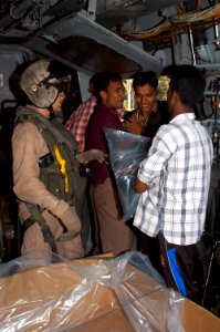 US Navy 071128-N-7955L-053 Citizens of Bangladesh help Marines from the 22nd Marine Expeditionary Unit (MEU) (Special Operations Capable) unload bags of fresh water from a U.S. Marine Corps CH-53 photo