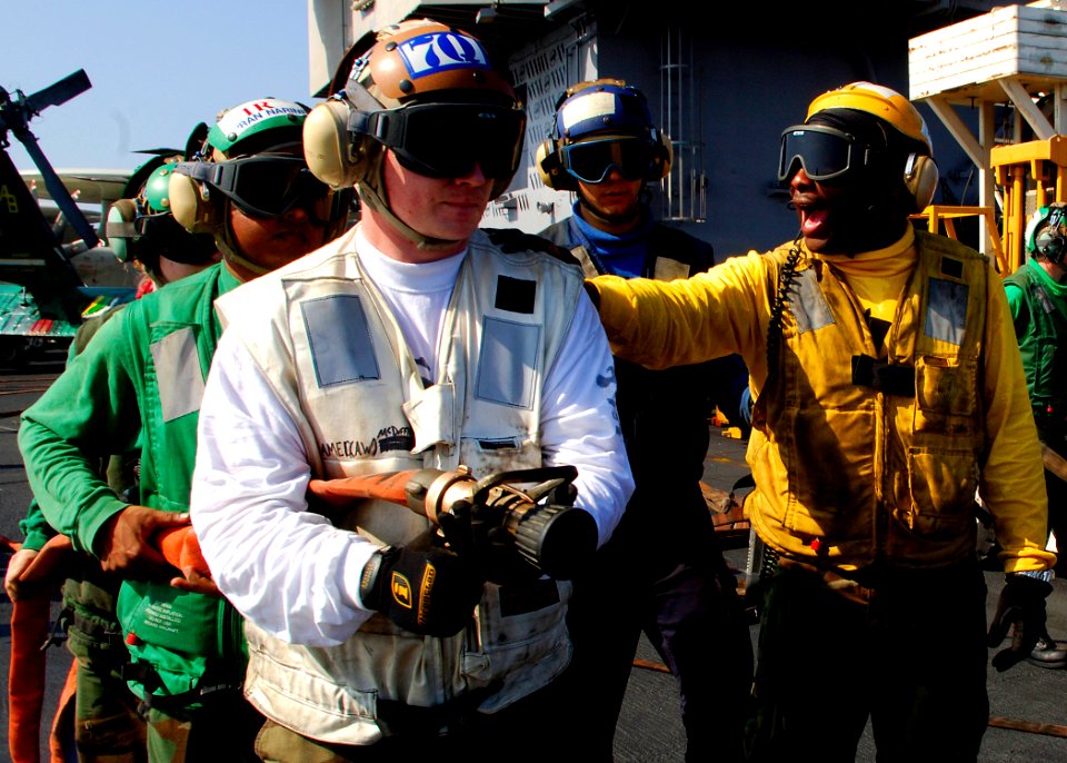US Navy 071128-N-8132M-010 Sailors assigned to the No. 1 hose team fight a simulated fire during a general quarters drill on the flight deck of the nuclear-powered aircraft carrier USS Enterprise (CVN 65)