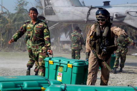 US Navy 071128-N-7955L-021 A Bangladesh Army solider and a Marine Corps aircrew chief unload containers of supplies from the CH-53E Sea Stallion helicopter attached to Marine Medium Helicopter Squadron (HMM) 261