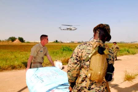 US Navy 071128-N-4010S-177 Chief Postal Clerk (SW-AW) Mike Kinstle and Master Gunnery Sgt. Patrick Holmes carry a package of medical supplies