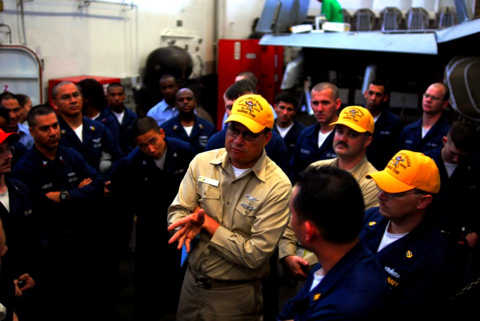 US Navy 071129-N-7526R-062 Senior Chief Ship's Serviceman (AW-SW) Hector Razo discusses a training evolution with repair locker 1B after a drill in the hangar bay of the aircraft carrier USS Ronald Reagan (CVN 76)