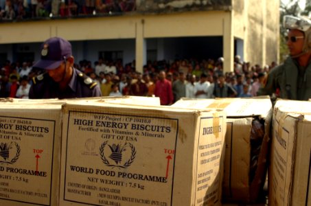 US Navy 071203-N-1831S-159 Boxes of relief supplies are piled near Bangladeshi citizens affected by Tropical Cyclone Sidr photo