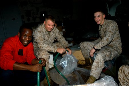 US Navy 071129-N-5642P-011 Sailors and Marines aboard the amphibious assault ship USS Kearsarge (LHD 3) fill water bags for distribution to the victims of Tropical Cyclone Sidr in Bangladesh photo