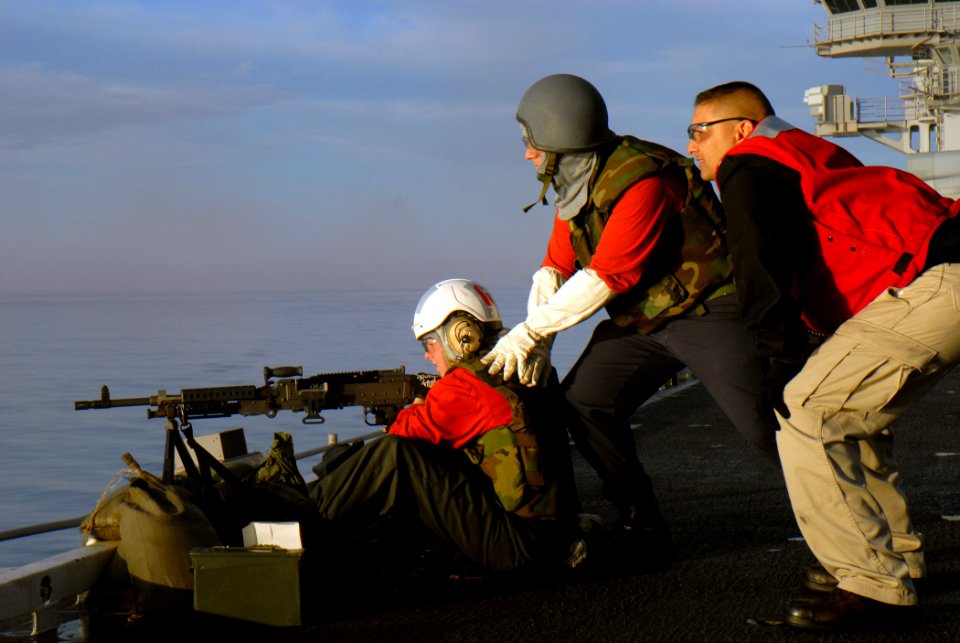 US Navy 071129-N-1635S-001 Aviation Ordnanceman 3rd Class Misty Beck, left, fires the M240 machine gun from the flight deck of the Nimitz-class nuclear-powered aircraft carrier USS Ronald Reagan (CVN 76)
