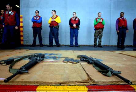 US Navy 071130-N-0555B-023 Sailors line the aircraft elevator door waiting for their turn to fire M-16s during a small arms exercise