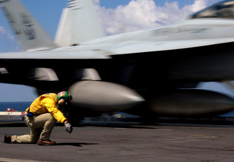 US Navy 071204-N-8923M-156 A shooter gives the final signal as an F-A-18F Super Hornet, attached to the Red Rippers of Strike Fighter Squadron (VFA) 11, launches from the bow aboard the Nimitz-class nuclear-powered aircraft car