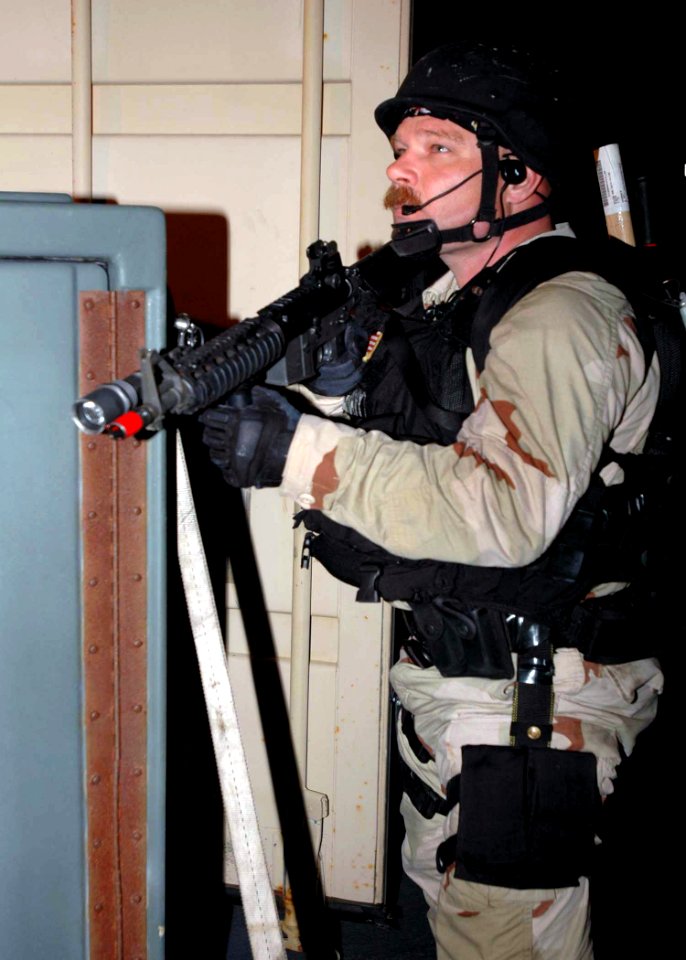 US Navy 071204-N-2838W-253 A member of USS Gonzalez's (DDG 64) visit, boarding, search and seizure team stands look-out as they take part in an actual real-time night boarding simulation of the training support vessel Prevail (