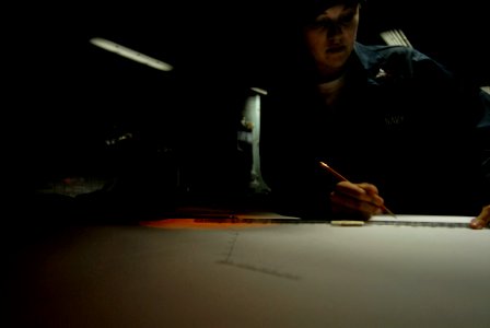 US Navy 071202-N-4133B-104 Operations Specialist 2nd Class Stephanie Rainwater plots courses in the commanding officer's tactical operations plotting aboard the Nimitz-class nuclear-powered aircraft carrier USS Ronald Reagan