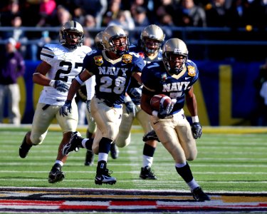 US Navy 071201-N-4565G-010 Midshipmen Reggie Campbell breaks free from the pack during a kick-off return for a touchdown during the second quarter of the 108th annual Army-Navy football game