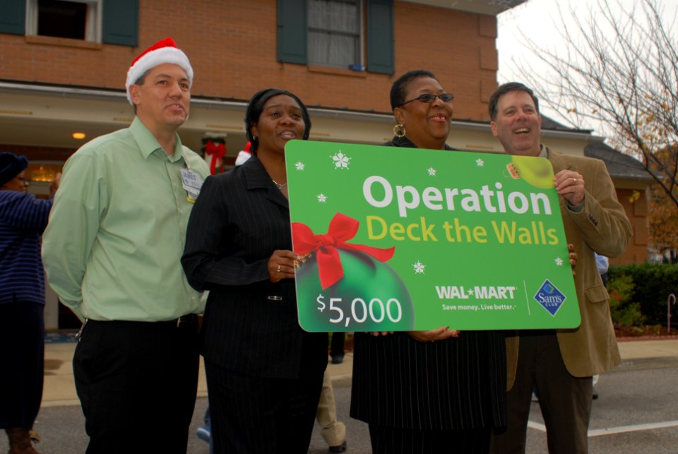 US Navy 071129-N-6676S-044 Mike VanHeest, far right, presents Loretta Loveless and Candice Edwards, of the Naval Medical Center Portsmouth (NMCP) Fisher House, stand with a $5,000 Wal-Mart gift card