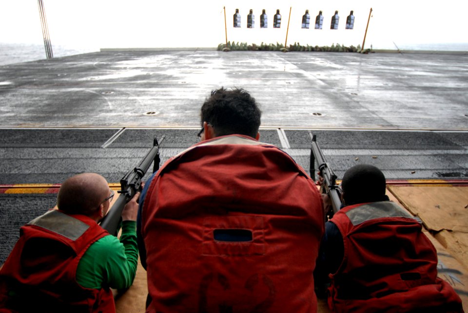 US Navy 071130-N-0555B-035 Gunner's Mate 3rd Class Anthony Castaneda, a line coach from the Weapons department aboard the Nimitz-class nuclear-powered aircraft carrier USS Ronald Reagan (CVN 76), watches over two Sailors firing
