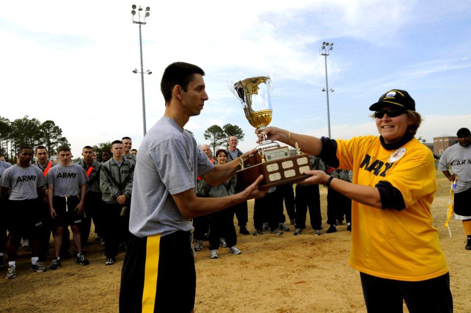 US Navy 071201-N-5328N-591 Army Capt. Bryan Hamilton receives the Center for Information Dominance (CID) Corry Station Flag Football Trophy from CID Commanding Officer Capt. Connie Frizzell following Army's 7-6 win over Navy at