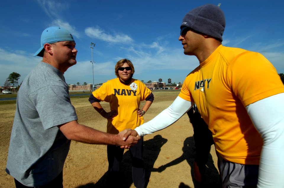 US Navy 071201-N-5328N-771 CID Corry Station CO Connie Frizzell looks on while football captains Staff Sgt. Greg Watlington and Cryptologic Technician (Maintenance) 2nd Class Chris Warren shake hands at the fifth annual Army-Na