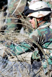 US Navy 071201-N-9623R-017 A member of Naval Mobile Construction Battalion (NMCB) 17 ensures that constantine wire is secure in place and at the right height from the ground