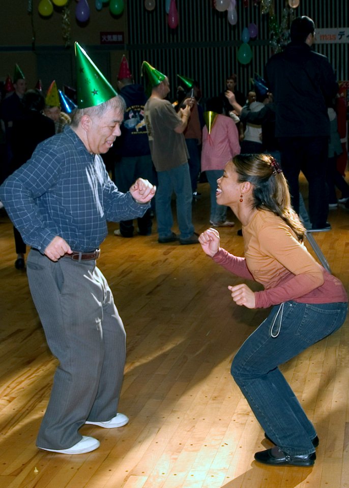 US Navy 071205-N-0483B-003 Yeoman 1st Class Equilla Sims dances with a member of Yokosuka's Sogo Fukushi Center during a disco party