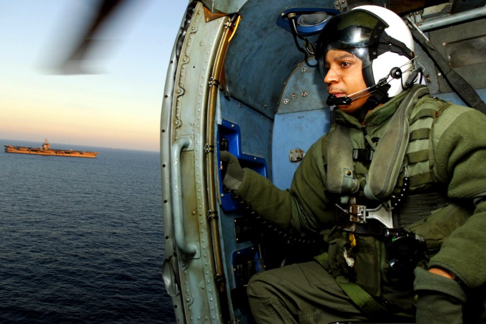 US Navy 071205-N-1598C-026 Aviation Warfare Systems Operator 2nd Class Brent Blackwell, looks out of from the doorway of a SH-60F Seahawk