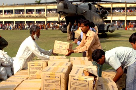 US Navy 071203-N-1831S-131 U.S. Marines and Sailors from the amphibious assault ship USS Kearsarge (LHD 3) and Bangladeshi citizens unload food and supplies from a CH-53E Super Stallion photo