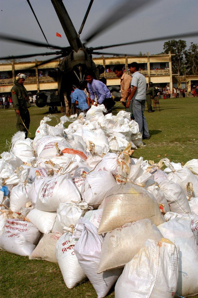 US Navy 071203-N-5642P-299 Local residents assist in unloading food supplies off of a CH-53E Super Stallion helicopter, attached to Marine Medium Helicopter Squadron (HMM) 261
