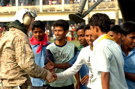 US Navy 071203-N-1831S-198 Bangladeshi citizens thank crew members assigned to the amphibious assault ship USS Kearsarge (LHD 3) for delivering food and other necessary supplies to them