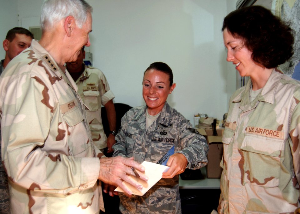 US Navy 071211-N-3285B-008 Staff Sgt. Ann Bleier and another member of Combat Camera on board Camp Lemonier ask Adm. William J. Fallon, commander, U.S. Central Command, to sign a Christmas card