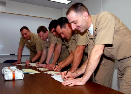 US Navy 071206-N-7656R-001 The chiefs aboard USS Ohio (SSGN 726) sign Christmas cards to be sent to other chiefs serving in the Middle East on Individual Augmentee assignments