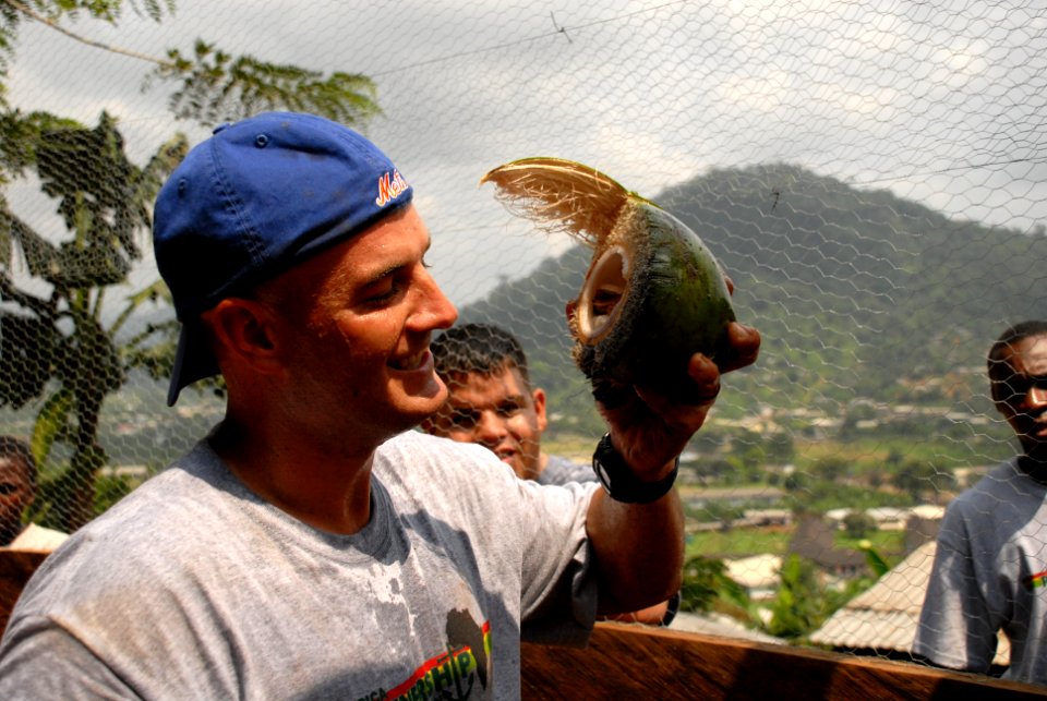 US Navy 071211-N-0193M-248 Sgt. Patrick Noll, an African Partnership Station (APS) volunteer takes a break from putting up chicken wire to eat a coconut he collected from a nearby tree