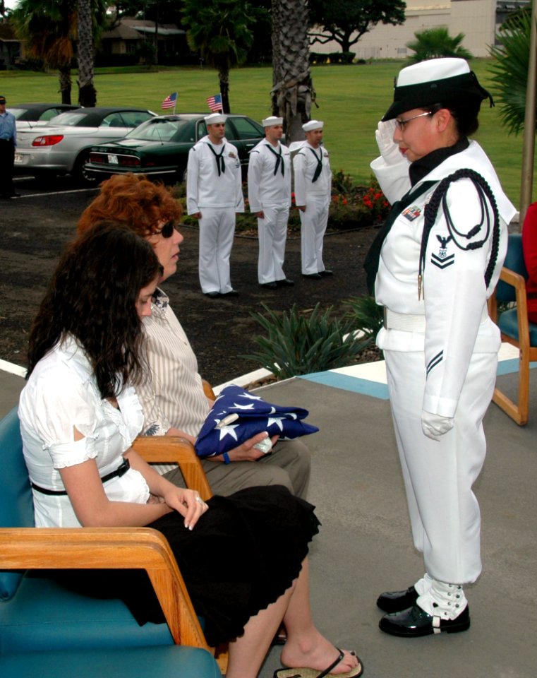 US Navy 071207-N-7310D-098 A Sailor assigned to Naval Station Pearl Harbor's honor guard presents Becky Johnson with an American Flag during an internment ceremony for her father, Richard Adams