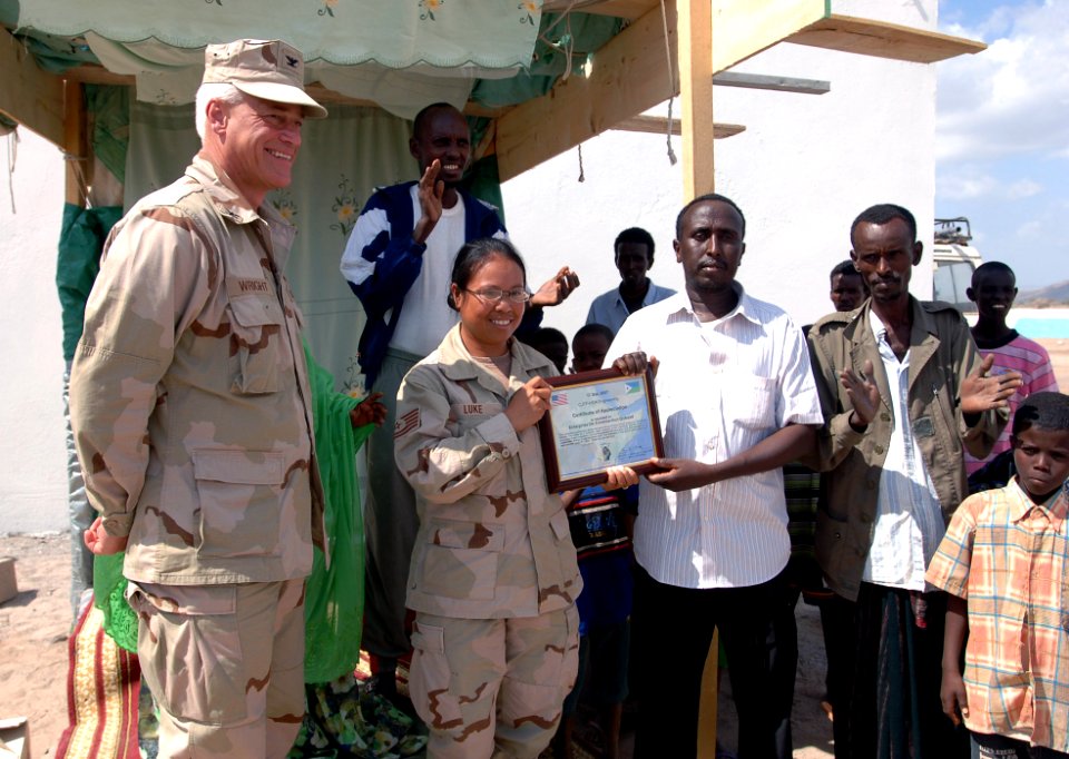 US Navy 071217-N-1003P-056 U.S. Navy Capt. Bob Wright, director, Combined Joint Task Force-Horn of Africa J-9 Strategic Communications, looks on as Tech. Sgt. Marrisa Luke, CJTF-HOA J-34, presents a certificate of appreciation