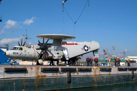 US Navy 071205-N-9520G-001 USS Kitty Hawk (CV 63) Sailors and Japanese contractors work together to secure an E-2C Hawkeye to a barge for transport to Naval Air Facility Atsugi for repairs