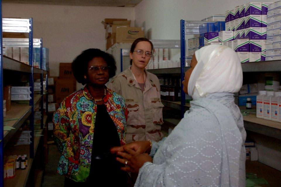 US Navy 071213-N-1003P-009 Navy Lt. Cmdr. Karen Corson and Janet Schulman listen as Dr. Coulibaly K. Abdi talks about some of the medical supplies