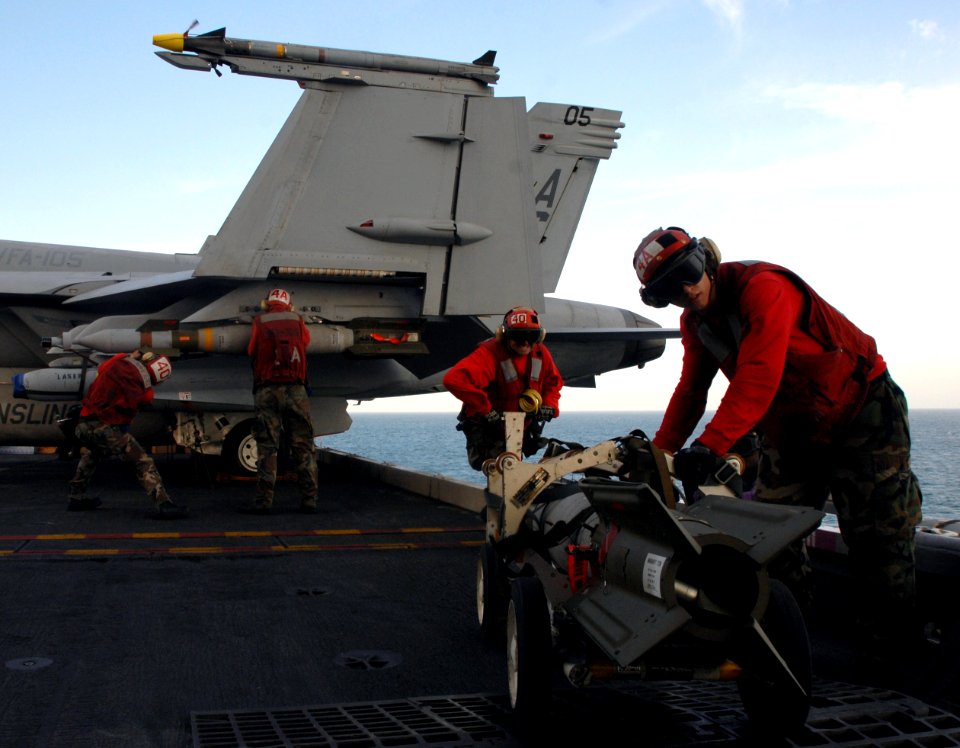 US Navy 071218-N-1688B-425 Aviation Ordnancemen load and unload bombs onto aircraft on the flight deck of the Nimitz-class nuclear-powered aircraft carrier USS Harry S. Truman (CVN 75)