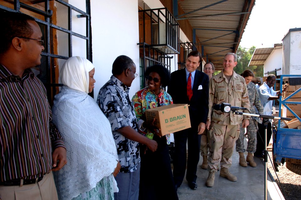 US Navy 071213-N-1003P-023 Navy Cmdr. Bobby Donovan, right, and W. Stuart Symington IV look on as Janet Schulman, hands over a box of medical supplies to the staff of Peltier Hospital