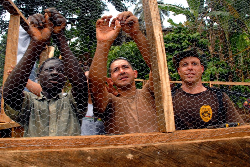 US Navy 071211-N-0193M-145 Construction Electrician 2nd Class Jose Castillo, center, takes time as an Africa Partnership Station (APS) volunteer to shows Limbe United Youth Associations volunteers how to secure chicken wire