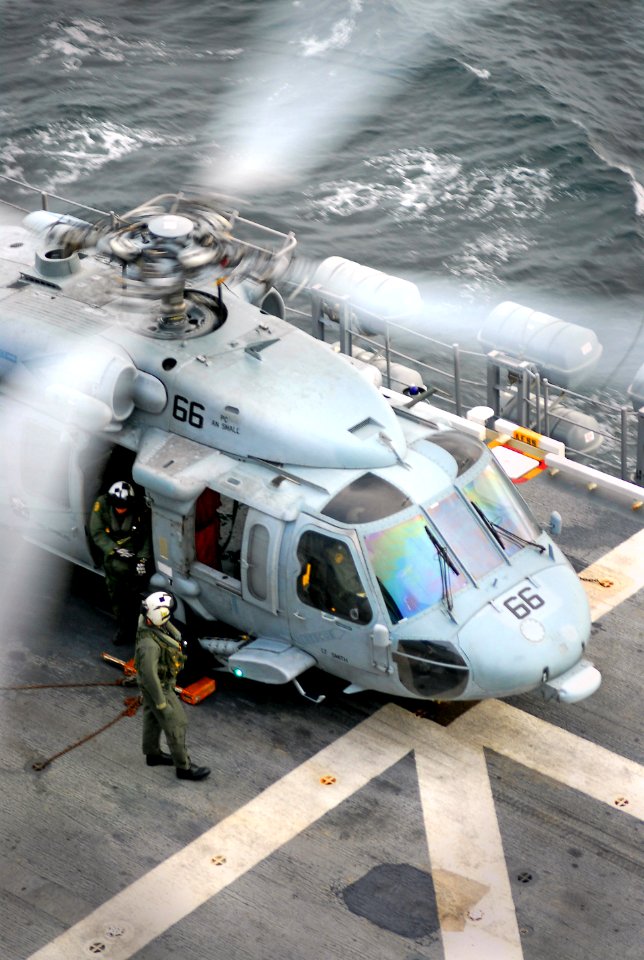 US Navy 071220-N-4774B-006 Aviation Warfare Systems Operators, attached to Helicopter Sea Combat Squadron (HSC) 21, inspect an MH-60S Seahawk before it takes off from the flight deck aboard the amphibious assault ship USS Taraw