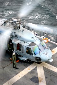 US Navy 071220-N-4774B-006 Aviation Warfare Systems Operators, attached to Helicopter Sea Combat Squadron (HSC) 21, inspect an MH-60S Seahawk before it takes off from the flight deck aboard the amphibious assault ship USS Taraw